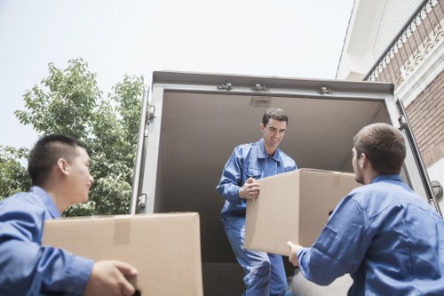 Prepared moving boxes and furniture ready for a removal van in Kilburn