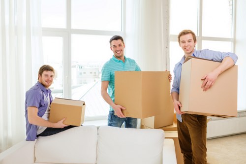 Professional movers carrying household items from a Kilburn flat