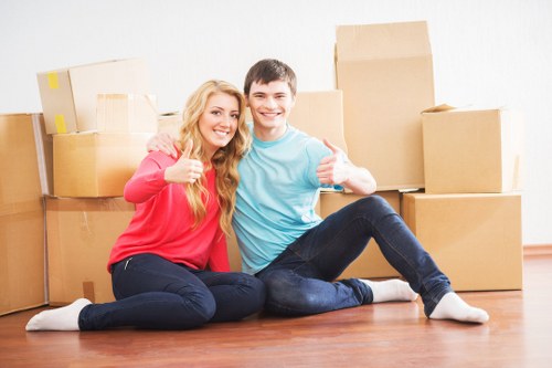 Unpacking boxes and arranging household items in a Kilburn home