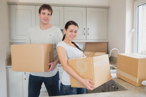 Local movers organising packed boxes inside a Kilburn flat for relocation